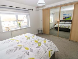 A bedroom with a bed and wardrobe at 15 Lawnswood in Saundersfoot