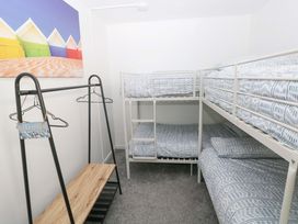 A bedroom with bunk beds and a clothing rack at 15 Lawnswood in Saundersfoot