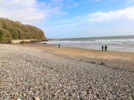 A beach with people walking near the water at 15 Lawnswood Saundersfoot