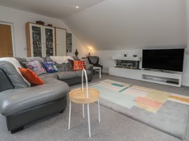 A living room with a sofa and television at Chy Holly in Carbis Bay