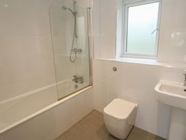 A bathroom with a bathtub, toilet, shower, and sink at Chy Holly in Carbis Bay