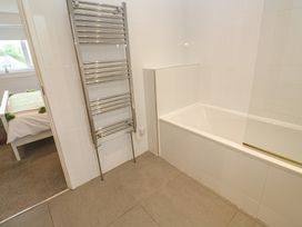 A bathroom with a bathtub and towel rail at Chy Holly in Carbis Bay