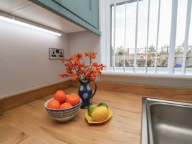 A kitchen with fruit and flowers on the worktop at Sea Roke in Filey