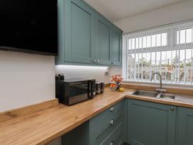 A kitchen with a sink and microwave at Sea Roke in Filey