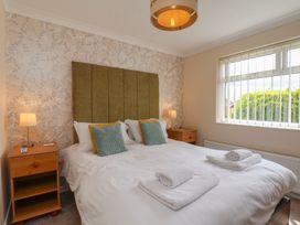 A bedroom with a bed and nightstand at Sea Roke in Filey