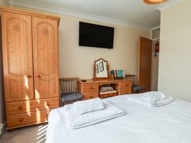 A bedroom with a wardrobe, television, and dresser at Sea Roke in Filey