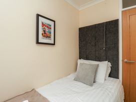 A bedroom with a single bed and wall art at Sea Roke in Filey