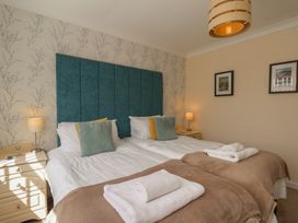 A bedroom with two beds and bedside tables at Sea Roke in Filey