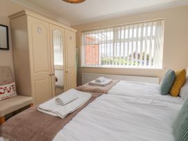 A bedroom with two beds and a wardrobe at Sea Roke in Filey