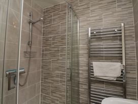 A bathroom with a shower and towel rail at Sea Roke in Filey