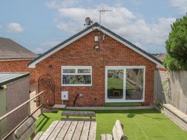 A garden with a brick house and outdoor seating at Sea Roke in Filey