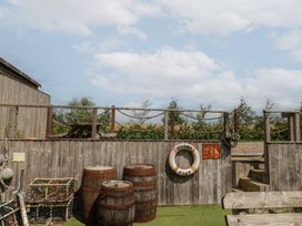 An outdoor area with barrels and a lifebuoy at Sea Roke in Filey