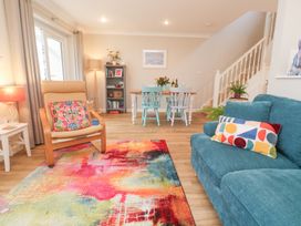 A living room with a sofa and dining area at Jaspers Retreat, formerly known as Starfish Cottage, Falmouth