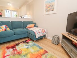 A living room with a sofa and television at Jaspers Retreat, formerly known as Starfish Cottage, Falmouth