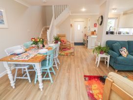 A living room with a dining area and staircase at Jaspers Retreat, formerly known as Starfish Cottage in Falmouth