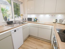 A kitchen with sink, dishwasher, and microwave at Jaspers Retreat, formerly known as Starfish Cottage, Falmouth