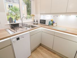 A kitchen with a sink, dishwasher, and microwave at Jaspers Retreat, formerly known as Starfish Cottage, Falmouth