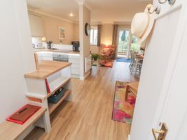 A kitchen with storage and seating area at Jaspers Retreat, formerly known as Starfish Cottage, Falmouth