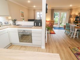 A kitchen with an oven and dining area at Jaspers Retreat, formerly known as Starfish Cottage, Falmouth