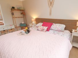 A bedroom with a bed and bedside table at Jaspers Retreat, formerly known as Starfish Cottage, Falmouth
