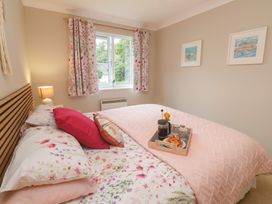 A bedroom with a bed and a tray of coffee and croissants at Jaspers Retreat, formerly known as Starfish Cottage, Falmouth