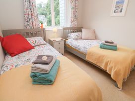 A bedroom with two single beds and a nightstand at Jaspers Retreat, formerly known as Starfish Cottage, Falmouth