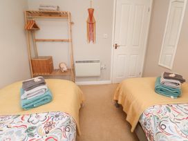 A bedroom with twin beds and towels at Jaspers Retreat, formerly known as Starfish Cottage, Falmouth