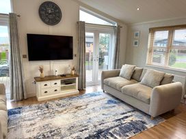 A living room with a television and sofa at Lodge 18 - The Pines Runswick Bay