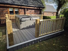 An outdoor area with a hot tub on a deck at Willow in Dolton