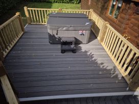 A deck with a hot tub and steps at Willow in Dolton