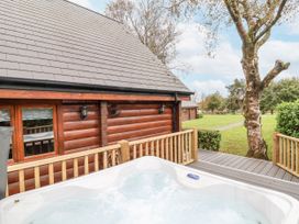 An outdoor space with a hot tub and a log cabin at Willow in Dolton