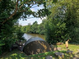 A tent by the water surrounded by trees at Willow in Dolton