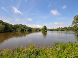 A lake surrounded by trees and grass at Willow in Dolton