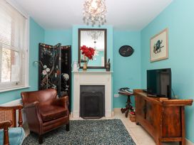 A living room with an armchair and television at 5 Exe Street Topsham