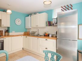 A kitchen with cabinets and a refrigerator at 5 Exe Street Topsham