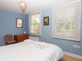 A bedroom with a bed and a chair at 5 Exe Street Topsham