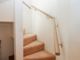 A staircase with carpeted steps and a handrail at 5 Exe Street Topsham