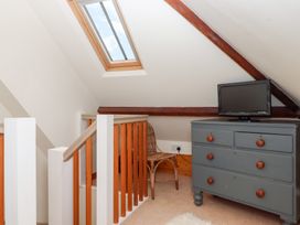 A loft area with a dresser and television at 5 Exe Street Topsham