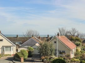 A row of houses with gardens and a view of the sea in the background at Rhos Retreat No 7 in Rhos On Sea