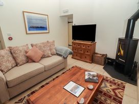 A living room with a sofa and a television at Cragg Lodge in West Woodburn