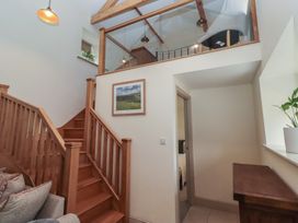 A hallway with a staircase and a framed picture at Cragg Lodge in West Woodburn