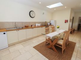 A kitchen with a dining table and appliances at Cragg Lodge in West Woodburn