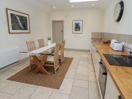 A kitchen with a dining table and chairs at Cragg Lodge in West Woodburn