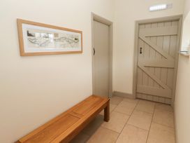 A hallway with a bench and framed artwork at Cragg Lodge in West Woodburn