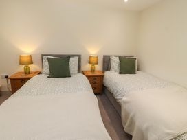 A bedroom with two beds and nightstands at Cragg Lodge West Woodburn