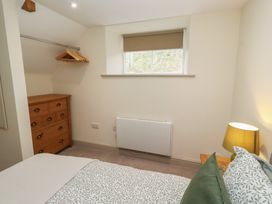 A bedroom with a bed and dresser at Cragg Lodge West Woodburn