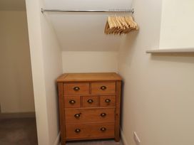 A storage room with a chest of drawers and hangers at Cragg Lodge West Woodburn