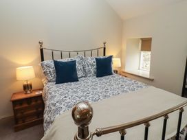 A bedroom with a bed and lamp at Cragg Lodge West Woodburn