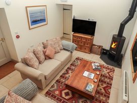 A living room with a sofa, television, and coffee table at Cragg Lodge in West Woodburn