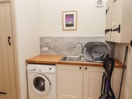 A utility room with washing machine and sink at Cragg Lodge in West Woodburn